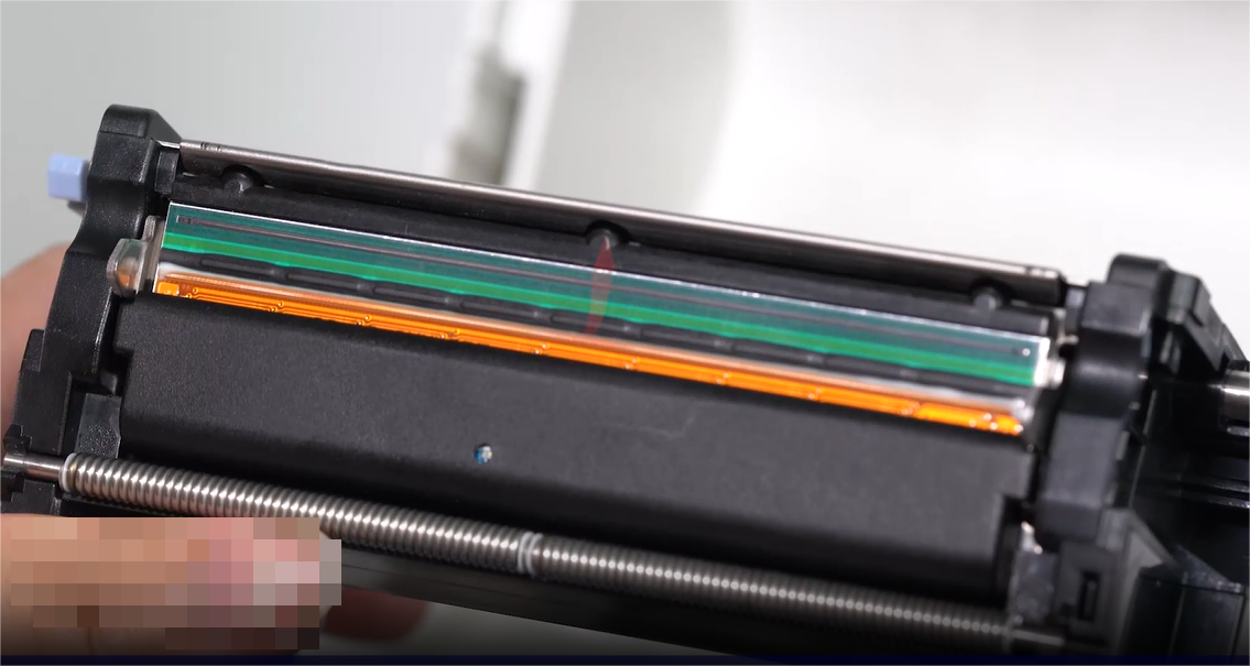 တစ်ခု close-up of a person carefully cleaning an electronic component with a swab.